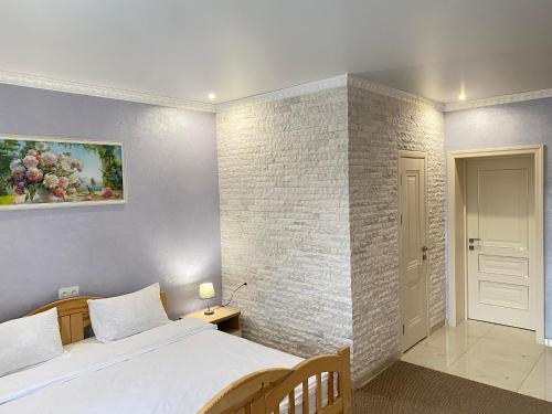 乌曼岛Park Hotel的一间卧室设有一张床和砖墙
