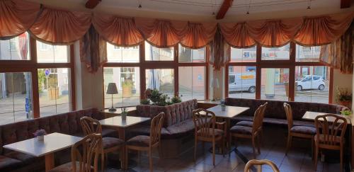 鲁拉Pension Jung, Bäckerei-Konditorei & Café的餐厅设有桌椅和窗户。