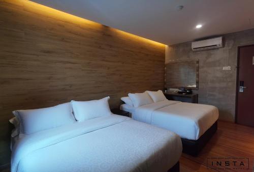 新山Insta Hotel JB的两张位于酒店客房的床,配有两张sidx sidx单人床