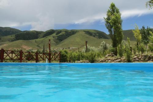 塔菲德尔瓦勒波萨达拉瓜达卢佩酒店的一座蓝色的游泳池,后面是群山