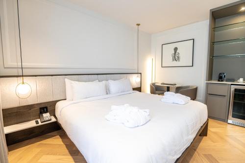 魁北克市Hôtel Boutique Ophelia的卧室配有带毛巾的大型白色床