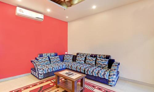 迈索尔Itsy By Treebo - Lotus Inn的客厅配有蓝色的沙发和桌子