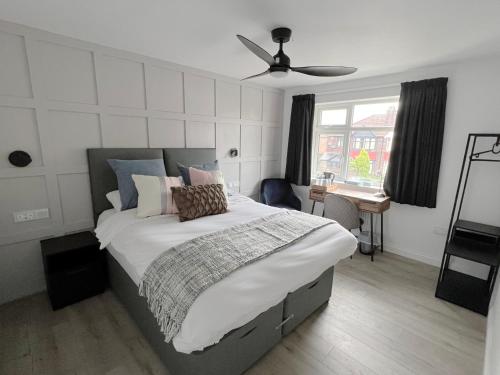 曼彻斯特United Home B&B的一间卧室配有一张大床和吊扇