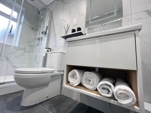 曼彻斯特United Home B&B的一间带卫生间和一束毛巾的浴室