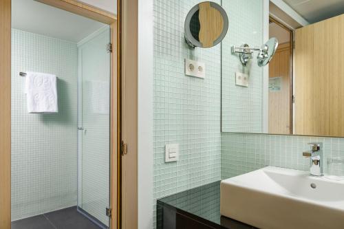 巴塞罗那加泰罗尼亚伊克斯普拉扎酒店的一间带水槽和镜子的浴室