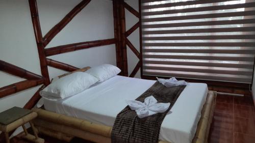 UlloaApto/cabaña naranja的卧室配有一张白色床和弓形床