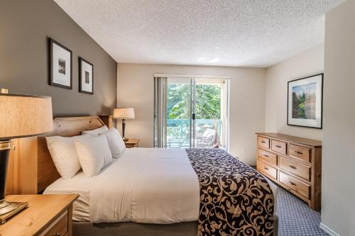 惠斯勒Snowbird by Elevate Vacations的一间卧室设有一张大床和一个窗户。