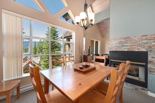 惠斯勒Snowbird by Elevate Vacations的一间带木桌和壁炉的用餐室