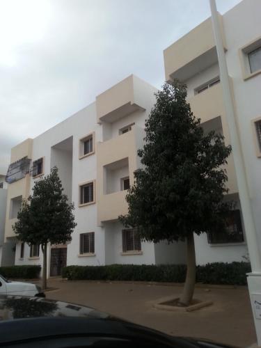 阿加迪尔Entire Apartment的前面有两棵树的白色建筑