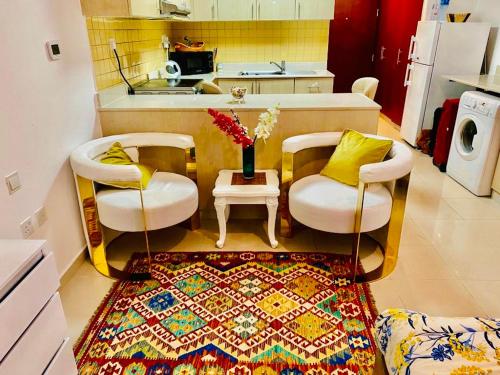 拉斯阿尔卡麦Rixos Beach Apartment的厨房配有两把椅子和一张桌子,地毯