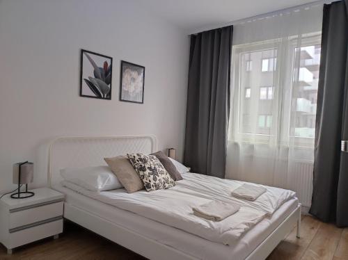 华沙Lux Apartment close to Medicover and Paley的卧室内的一张白色床,设有窗户