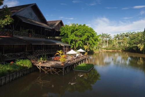 山打根Sepilok Nature Lodge - Formerly known as Sepilok Nature Resort的河上设有桌椅的建筑