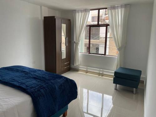 特鲁希略Exclusivo Apartamento en el Centro Histórico Trujillo - 3er Piso的卧室配有床、椅子和窗户。