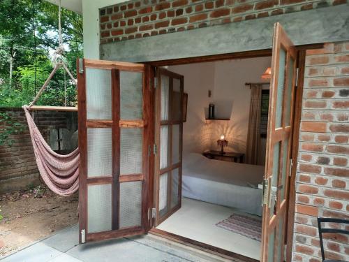 蓬蒂切里Isai Ambalam guest house的通往带吊床的卧室的开放式门