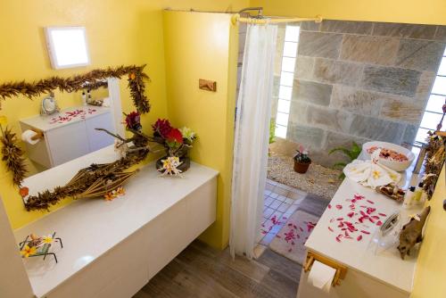 波拉波拉Fare Manava的浴室设有黄色的墙壁、水槽和镜子
