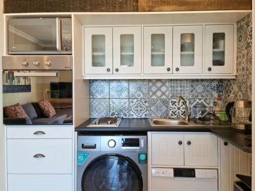 戈登湾Apartment18Lifestyle Gordons Bay Beachfront的厨房配有洗衣机和水槽
