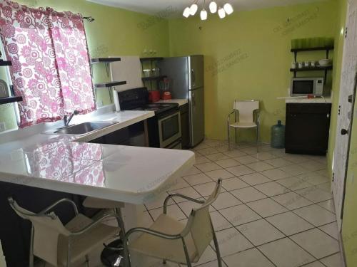 圣卡洛斯Casa Tecalai 5的厨房配有水槽和一些椅子