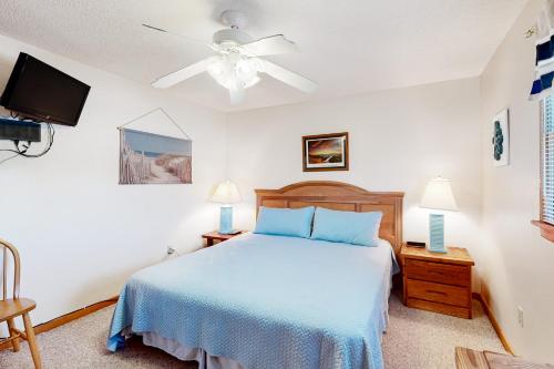 SalvoSurfing Kitty的一间卧室配有蓝色的床和一台平面电视