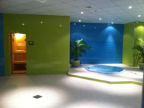 Al WakrahWakra Inn Hotel Apartments的带浴缸和绿色墙壁的浴室
