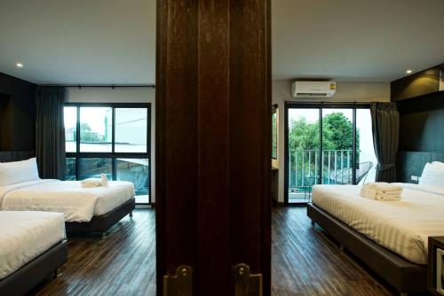 清迈Sleep Mai Thapae Chiang Mai Old City Lifestyle Hotel - SHA Plus的酒店客房设有两张床和一个阳台。
