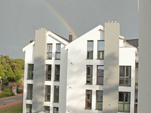 巴贝Strandvilla Baabe - Maisonette "Sonnenwiege" mit Sauna und Whirlpool的白色建筑上方的天空彩虹