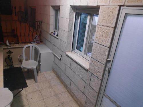 伯利恒Fully Furnished Apartment in Bethlehem Center的一个小浴室,配有窗户和椅子