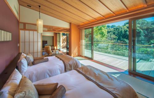 伊东ABBA Resorts Izu - Zagyosoh的一间卧室设有两张床和大窗户