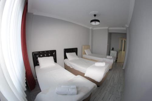 PazarDelpina APART - Doğa içinde deniz manzaralı的带3张床和白色枕头的客房