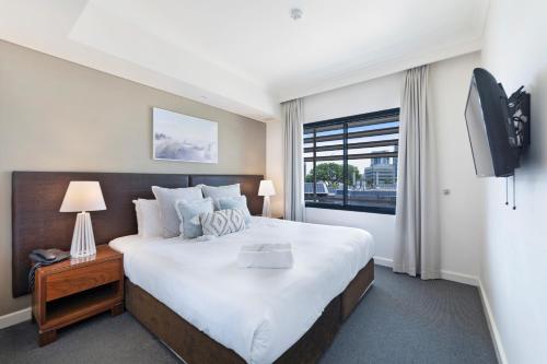 达尔文Exclusive Resort-style Living with Balcony & Pool的一间卧室配有一张大床和电视