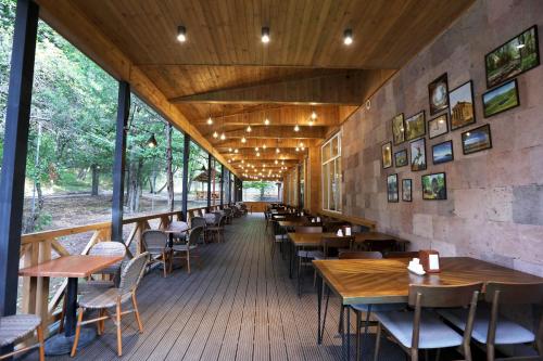阿格沃兰阿弗兰公园度假酒店的餐厅设有木桌、椅子和窗户。