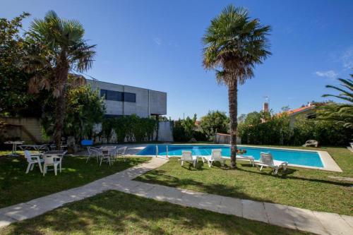 波多诺伏House - 3 Bedrooms with Pool WiFi and Sea views - 7428的一座带椅子的游泳池,一座棕榈树旁边