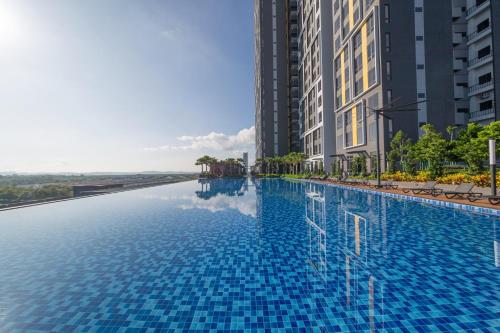 Kampong PendasSunway Grid Loft Suite by Nest Home【Olympic Size Pool】的两个高楼中间的一个游泳池