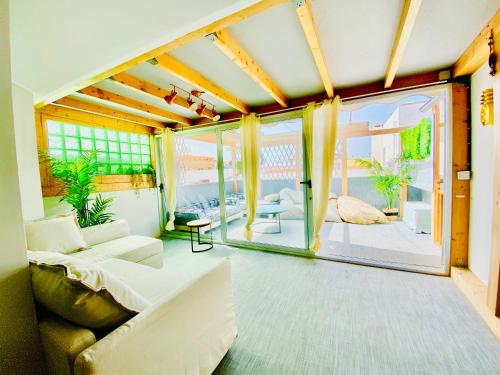 科拉雷侯Golden Wave Surf Roof Terrace的带沙发和大窗户的客厅