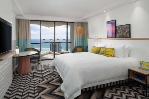 黄金海岸黄金海岸QT精品度假酒店的酒店客房设有一张大床和一个阳台。