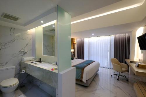 库塔Dream of Aventus Hotel Kuta的一间酒店客房 - 带一张床和一间浴室