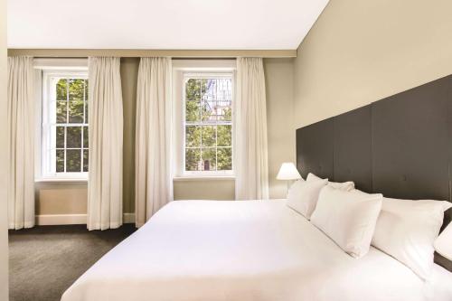 阿德莱德阿德莱德财政大楼阿迪那公寓酒店的卧室配有一张白色大床和两个窗户