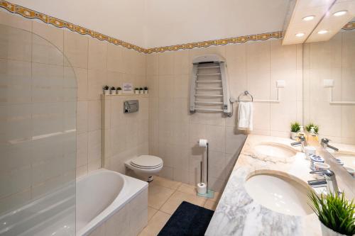 卡武埃鲁Casa Madrugada的一间带两个盥洗盆、浴缸和卫生间的浴室
