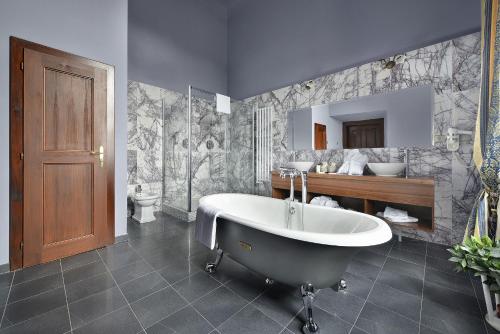 娄切尼卢森花园城堡酒店的带浴缸、盥洗盆和卫生间的浴室