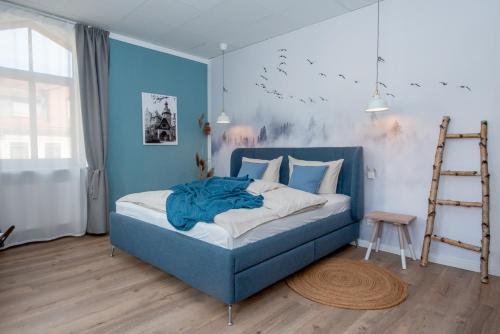 艾森纳赫Apartment Kronprinz zentral mit Infrarot-Sauna的一间卧室配有蓝色的床和梯子