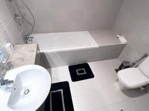 阿布扎比SeaView Inn的浴室配有盥洗盆、卫生间和浴缸。
