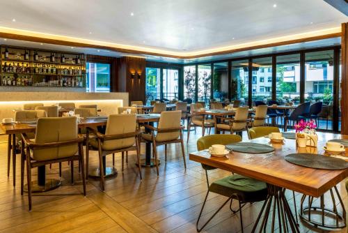 伊斯坦布尔Tzl Suites Hotel Nişantaşı的餐厅设有木桌、椅子和窗户。