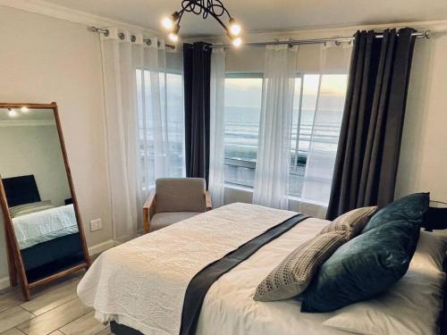 布鲁堡史特兰Luxurious 2-bedroom beach apartment with a view!的一间卧室设有一张大床和一个大窗户