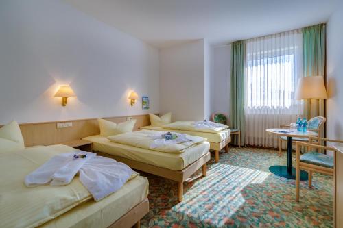 阿尔滕堡阿斯特酒店的酒店客房设有两张床和一张桌子。