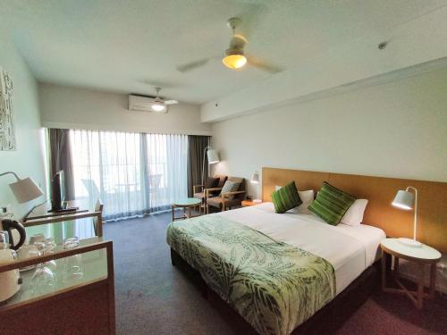 达尔文Darwin Harbour Suite的酒店客房设有一张大床和一张书桌。