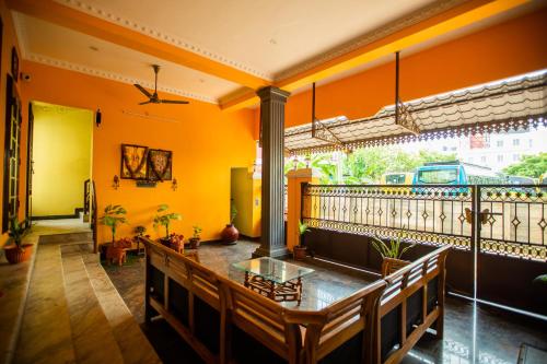 蓬蒂切里Sri Balaji Villas的一间拥有橙色墙壁、桌子和长凳的房间