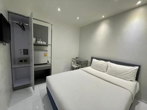 曼谷My Hotel Pratunam的一间白色卧室,配有床和微波炉