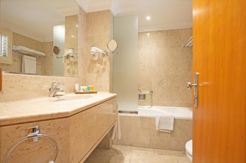 迪拜迪拜海滩Spa度假酒店的一间带水槽、浴缸和卫生间的浴室