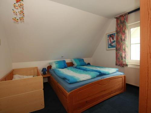 青斯特FW Lehmann的一间卧室配有一张带蓝色枕头的床和一扇窗户。