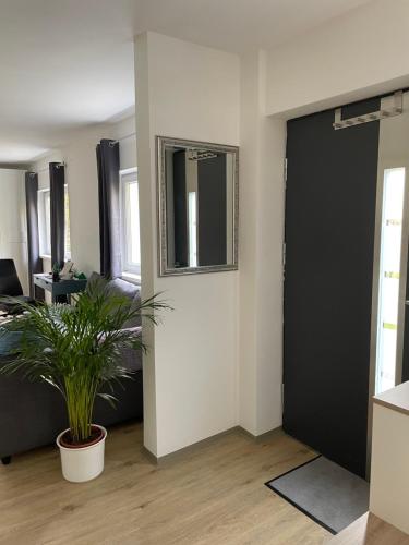 格拉茨Ruhiges Appartement im Grünen的一间客厅,配有黑色的门和植物