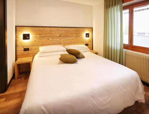 拉特乌伊莱TH La Thuile - Planibel Residence的卧室配有一张带两个枕头的大白色床